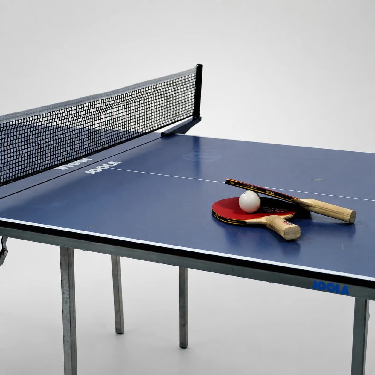 Ausschnitt der Tischtennisblatte mit 2 Tischtennisschlägern und 1 Tischtennisball 
