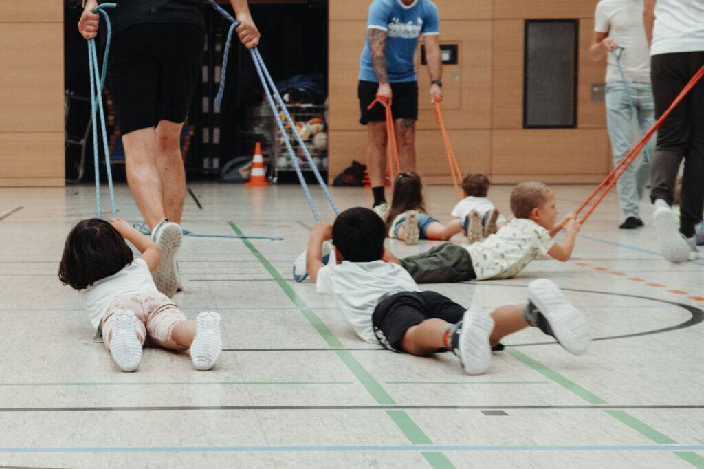 Kinderturnen | Eltern Kind Sport | Kindersport Dresden | Kinder lassen sich an Seilen ziehen